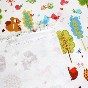 May include: A white fabric featuring a repeating pattern of brown squirrels, green and blue stylized trees, red and blue birds, snails, and small flowers. The fabric has a visible frayed edge and a stitched hem along the bottom section.