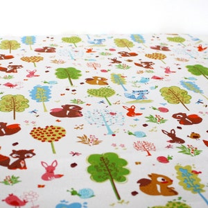 May include: A white fabric featuring a repeating pattern of colorful woodland elements including brown squirrels, orange foxes, blue birds, green trees, pink snails, and small floral motifs scattered across the surface in a dense, illustrative design.