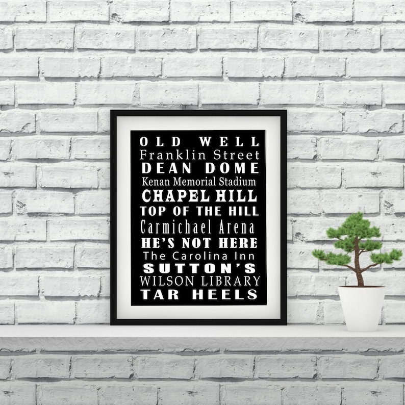 Op de afbeelding: Zwart-wit typografisch drukwerk met de woorden "Old Well", "Franklin Street", "Dean Dome", "Chapel Hill", "Top of the Hill", "Carmichael Arena", "He's Not Here", "The Carolina Inn", "Sutton's", "Wilson Library" en "Tar Heels".