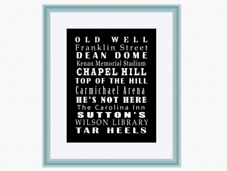 Op de afbeelding: Zwart-wit typografieprint met de tekst "Old Well", "Franklin Street", "Dean Dome", "Kenan Memorial Stadium", "Chapel Hill", "Top of the Hill", "Carmichael Arena", "He's Not Here", "The Carolina Inn", "Sutton's", "Wilson Library" en "Tar Heels".