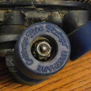 May include: Close-up of a blue roller skate wheel with the text "California Free Former Urethane" printed on it.