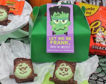 May include: Green and purple Halloween treat boxes with Frankenstein faces and the text "Let me be Frank, you're the sweetest!"  The boxes are filled with chocolate and brownies.