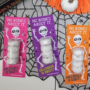 May include: Four Halloween treat bags with a skeleton graphic and the text "No Bones About It, Halloween is Sweet!"  The bags are pink, purple, orange, and green.