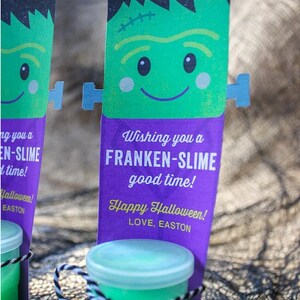 Puede incluir: Una tarjeta verde con tem&aacute;tica de Frankenstein con el texto "Wishing you a Franken-Slime good time! Happy Halloween! Love, Easton" adjunta a un peque&ntilde;o frasco transparente lleno de slime verde.