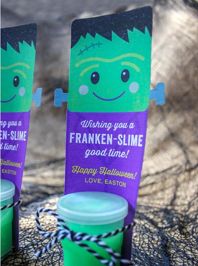 Puede incluir: Una tarjeta verde con tem&aacute;tica de Frankenstein con el texto "Wishing you a Franken-Slime good time! Happy Halloween! Love, Easton" adjunta a un peque&ntilde;o frasco transparente lleno de slime verde.