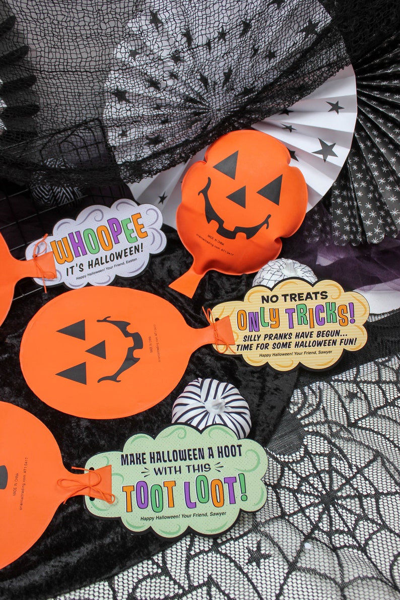 May include: Three orange pumpkin-shaped Halloween party favours with black jack-o'-lantern faces. Each favour has a different message: "Whoopie It's Halloween!", "No Treats Only Tricks! Silly Pranks Have Begun... Time For Some Halloween Fun!" and "Make Halloween A Hoot With This Toot Loot!"