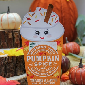 Może przedstawiać: Festiwalowa pomarańczowa i biała karta podarunkowa z wzorem latte z przyprawą dyniową. Na karcie napisano "Wishing you Pumpkin Spice and everything nice! Thanks a latte for all you do! Love, The McKowns".