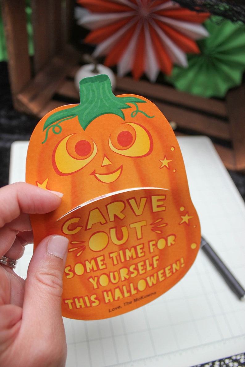 May include: A bright orange pumpkin-shaped card with a friendly face and the text "CARVE OUT SOME TIME FOR YOURSELF THIS HALLOWEEN! Love, The McKowns"