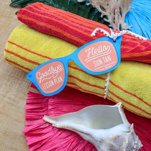 May include: A pair of blue paper sunglasses with the words "Goodbye Lesson Plan" on one lens and "Hello Sun Tan Thanks for a great year! Love, Sawyer" on the other lens. The sunglasses are on top of two yellow and orange striped towels.