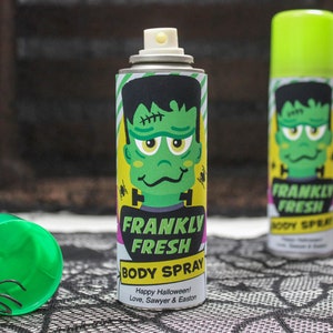 Puede incluir: Dos botellas de spray verdes y amarillas con un gráfico de monstruo de Frankenstein y el texto "Frankly Fresh Body Spray". El texto "Happy Halloween! Love, Sawyer & Easton" está impreso en la parte inferior de la botella.