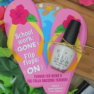 May include: Pink and blue flip flop shaped card with the text "School work: GONE Flip flops: ON" and the message "Thanks for being a toe-tally awesome teacher! Have a great summer! Love, Sawyer". The card is decorated with a pink hibiscus flower and a small bottle of white nail polish.