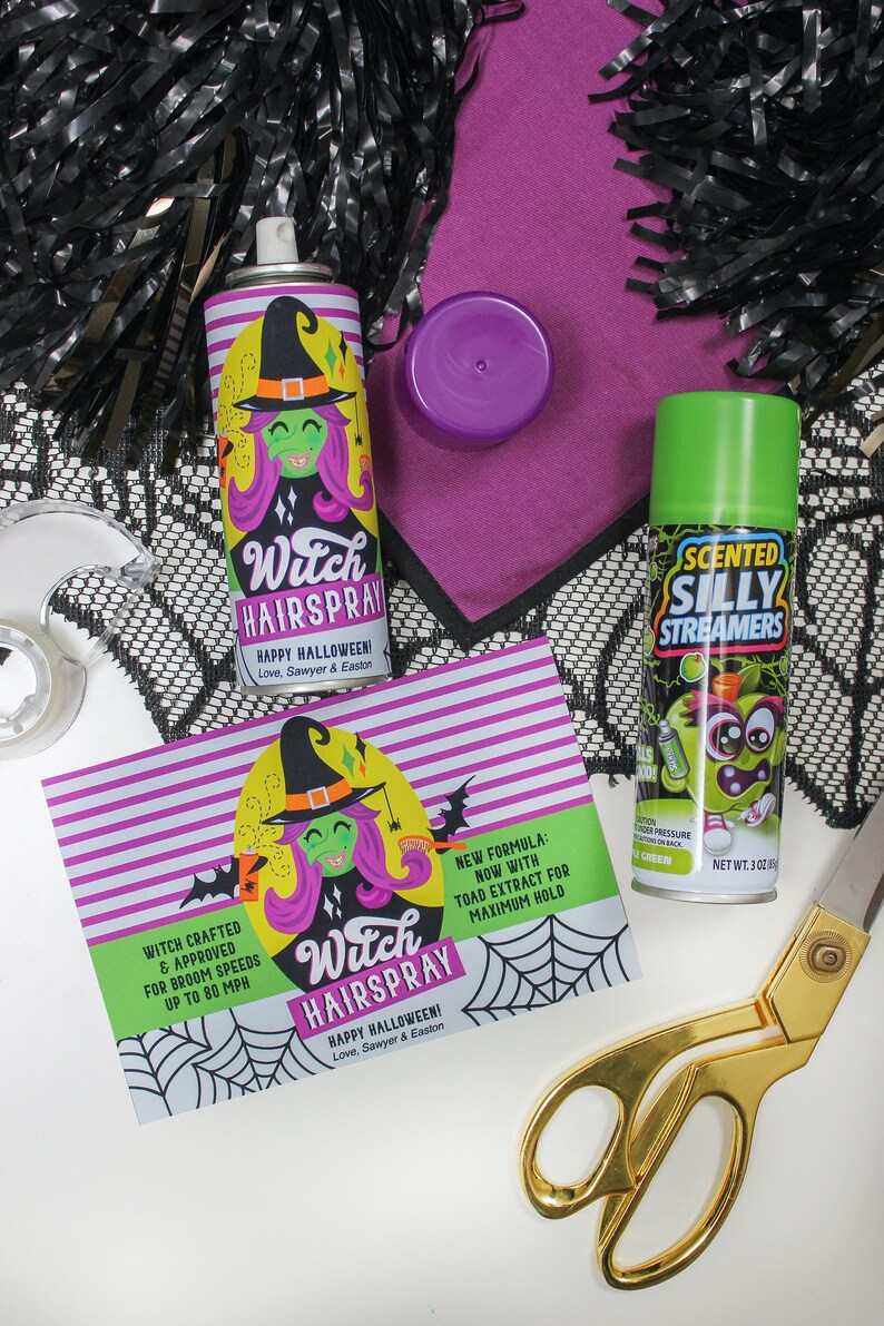 May include: Two green and white cans of hairspray with a witch cartoon on the front. The cans are labeled "Witch Hairspray" and "Scented Silly Streamers". The cans are on a white surface with black and white lace, purple fabric, and gold scissors.
