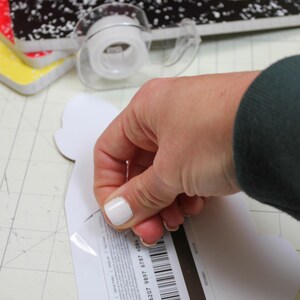 May include: A white gift card with a black barcode and the text "CARD#: 6207 9897 6787 4084" on the back. The card is being peeled off of a white paper backing.