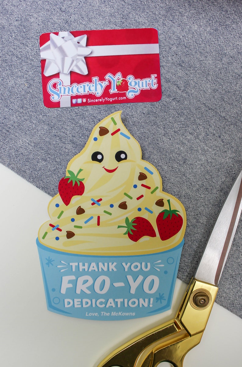 May include: A blue and white card with a cartoon yogurt cup with a smiling face. The yogurt cup is topped with strawberries, chocolate chips, and sprinkles. The card says "Thank You Fro-Yo Dedication! Love, The McKowns".