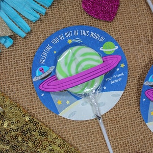 Op de afbeelding: Een groene en witte swirl lollipop met een roze en paarse ring eromheen. De lollipop is bevestigd aan een stok en bevindt zich op een blauwe en witte cirkel met de tekst "Valentine, you're out of this world!" en "Your Friend, Sawyer".