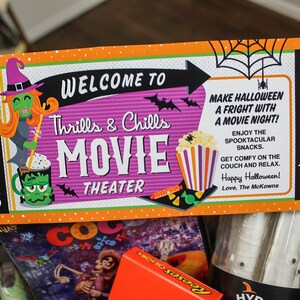 May include: A Halloween movie night gift basket with a ticket that says "Welcome to Thrills & Chills Movie Theater". The basket includes a movie, popcorn, candy, and other treats.
