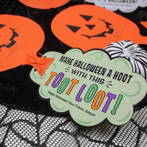 May include: A green and purple Halloween party favour with the text "Make Halloween a Hoot with this Toot Loot!" and "Happy Halloween! Your Friend, Sawyer".