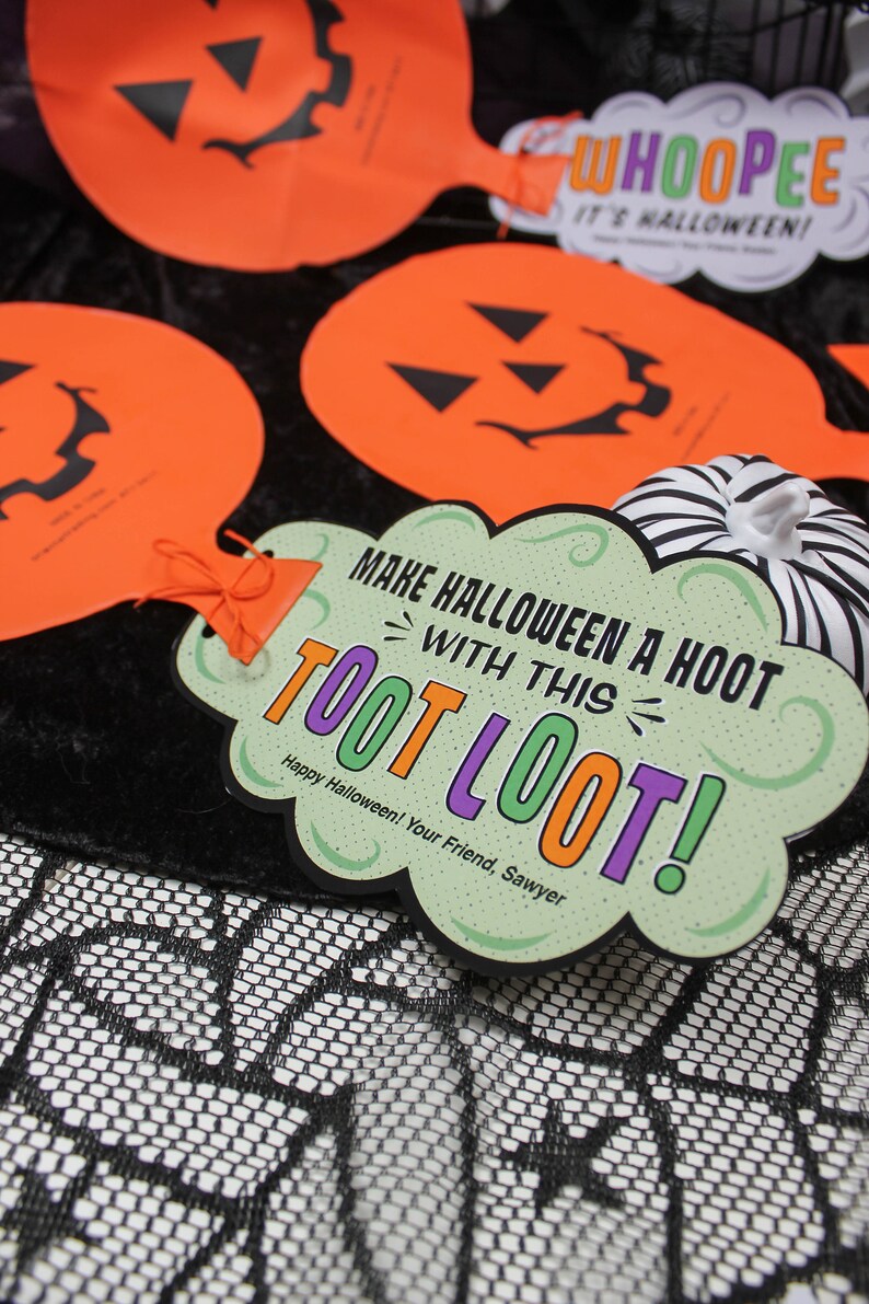 May include: A green and purple Halloween party favour with the text "Make Halloween a Hoot with this Toot Loot!" and "Happy Halloween! Your Friend, Sawyer".