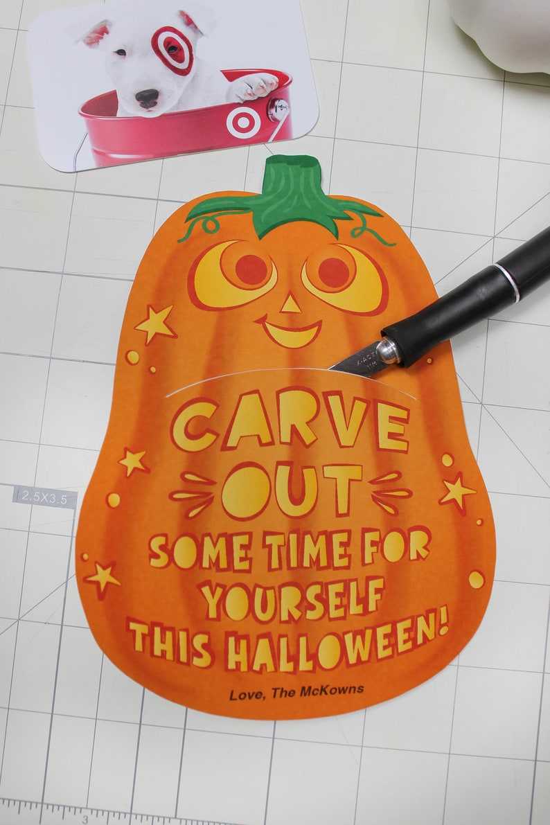 May include: Orange pumpkin-shaped card with a smiling jack-o'-lantern face and the text "Carve out some time for yourself this Halloween! Love, The McKowns".
