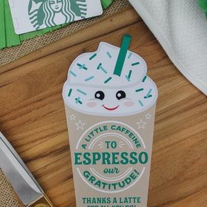 May include: A brown paper cup with a green and white cartoon coffee cup design. The cup has a smiling face and sprinkles. The text on the cup reads "A little caffeine to espresso our gratitude! Thanks a latte for all you do! Love, The McKowns".