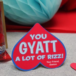 May include: A red heart-shaped card with blue trim reads "You Gyatt A Lot Of Rizz!" with the text "Your Friend, Easton" at the bottom.
