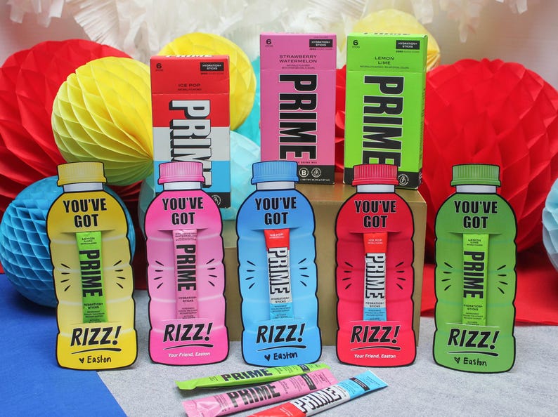 May include: Five colourful pouches with the text "You've Got Prime" and "Rizz!"  The pouches contain individual drink mixes. The pouches are arranged in a row on a table with a blue and white checkered background.