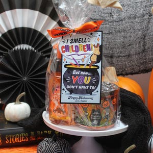 May include: A Halloween gift basket with a cauldron-shaped tag that reads "I smell children! But now... you don't have to!" The basket includes a pumpkin-scented candle and a bottle of hand sanitizer.