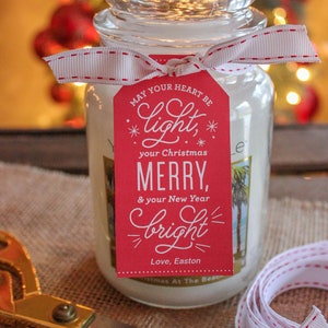 May include: A white candle jar with a red gift tag that reads "May your heart be *light*, your Christmas MERRY, & your New Year *bright*" with the signature "Love, Easton".