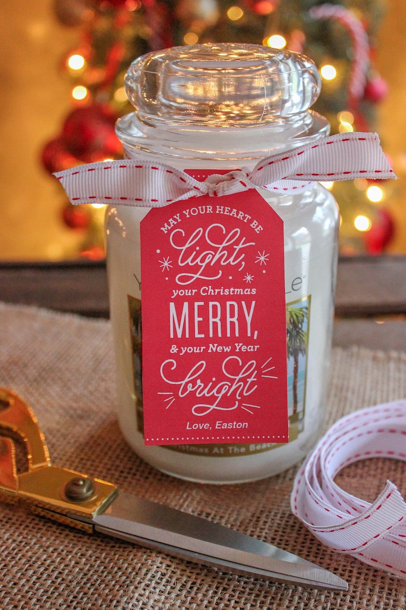 May include: A white candle jar with a red gift tag that reads "May your heart be *light*, your Christmas MERRY, & your New Year *bright*" with the signature "Love, Easton".