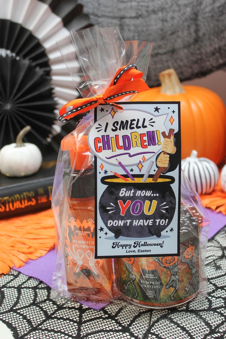 May include: A Halloween gift bag with a tag that reads "I smell children! But now... you don't have to!" The bag contains a pumpkin-scented hand sanitizer and a pumpkin carving candle. The tag is decorated with a witch's cauldron and a broom.