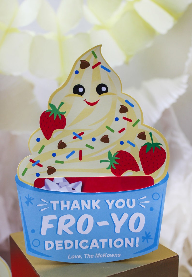 May include: A blue and red thank you card with a cartoon image of a smiling frozen yogurt cup with chocolate chips, sprinkles, and strawberries. The text on the card reads "Thank You Fro-Yo Dedication! Love, The McKowns".