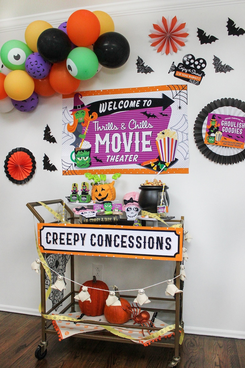 May include: A Halloween-themed party cart with a sign that reads "Creepy Concessions". The cart is decorated with orange, black, and white decorations, including a ghost garland, a pumpkin, and a spider. The cart is also decorated with a sign that reads "Welcome to Thrills & Chills Movie Theater".