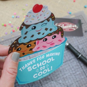 Puede incluir: Una tarjeta de cono de helado azul y blanco con una cara sonriente y el texto "Gracias por hacer la escuela tan genial! Con cari&ntilde;o, Sawyer".
