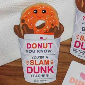 May include: A donut-themed card with a cartoon donut in a coffee cup. The card reads "Donut you know... you're a slam dunk teacher!" and is signed "Love, Sawyer".