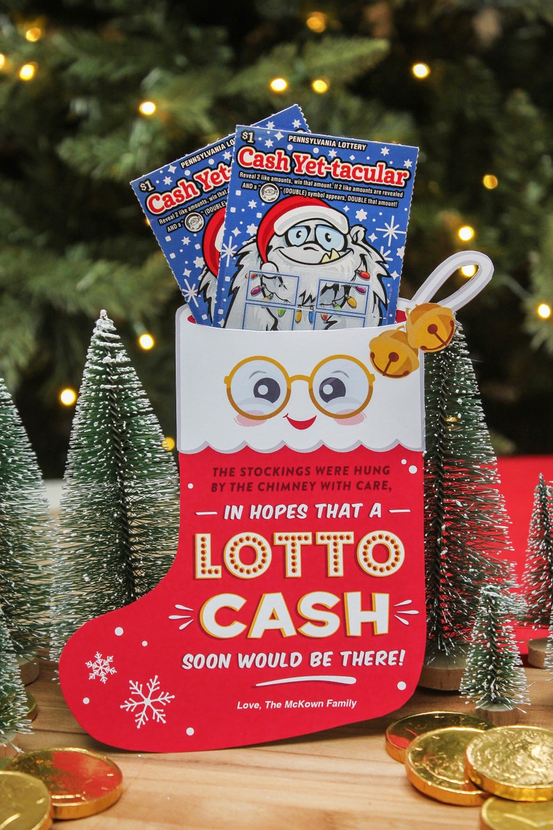 Pode incluir: Uma meia vermelha com um rosto de boneco de neve branco, &oacute;culos e sinos. A meia est&aacute; cheia de dois bilhetes de loteria que dizem "Cash Yet-tacular". O texto na meia diz "The stockings were hung by the chimney with care, - In hopes that a - Lotto Cash - soon would be there! Love, The McKown Family."