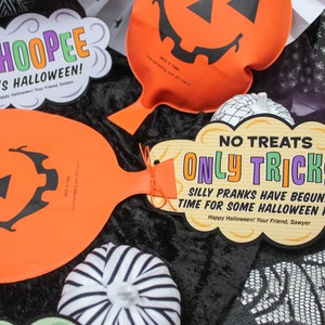 May include: Three orange pumpkin-shaped balloon decorations with black jack-o'-lantern faces. The balloons have strings attached and are decorated with tags that say "WHOOPEE IT'S HALLOWEEN!" and "NO TREATS ONLY TRICKS! SILLY PRANKS HAVE BEGUN... TIME FOR SOME HALLOWEEN FUN!"