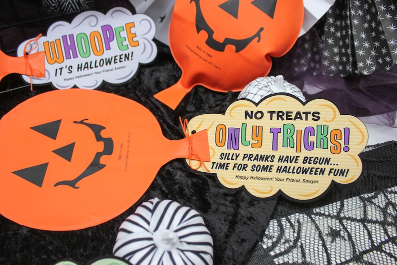 May include: Three orange pumpkin-shaped balloon decorations with black jack-o'-lantern faces. The balloons have strings attached and are decorated with tags that say "WHOOPEE IT'S HALLOWEEN!" and "NO TREATS ONLY TRICKS! SILLY PRANKS HAVE BEGUN... TIME FOR SOME HALLOWEEN FUN!"