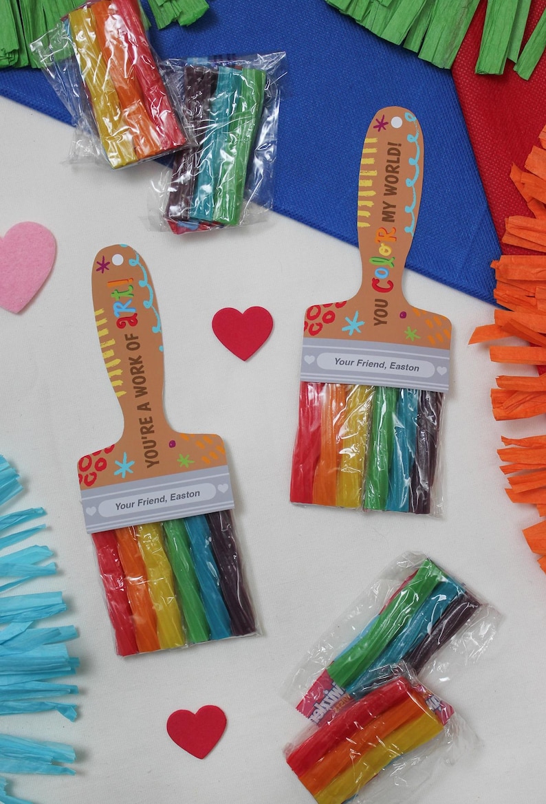 May include: Colorful rainbow-colored candy sticks packaged in clear plastic, arranged in the shape of a paintbrush. The paintbrush-shaped card reads "YOU'RE A WORK OF ART!" and "YOU COLOR MY WORLD!" with the text "Your Friend, Easton".