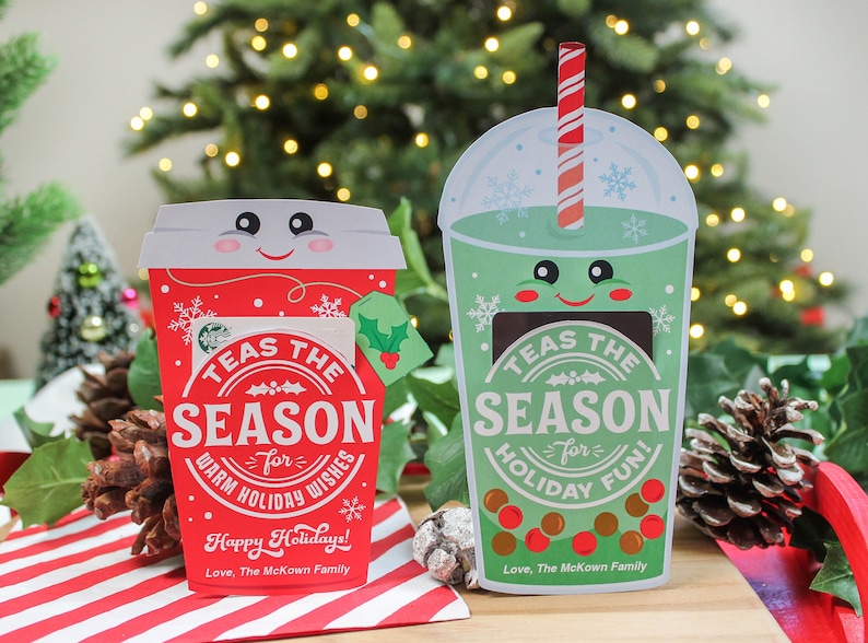 Pode incluir: Dois cart&otilde;es-presente com tema natalino em forma de x&iacute;cara de caf&eacute; vermelha e x&iacute;cara de ch&aacute; de bolhas verde. Ambas as x&iacute;caras t&ecirc;m um rosto sorridente e o texto "TEAS THE SEASON" com uma mensagem festiva abaixo.