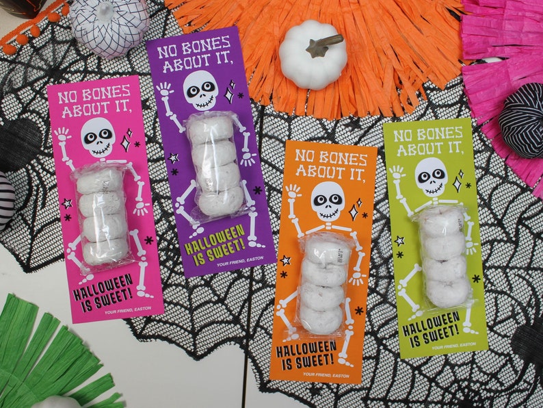 May include: Four Halloween-themed treat bags with a skeleton graphic and the text "No bones about it, Halloween is sweet!"  Each bag contains a stack of mini donuts.