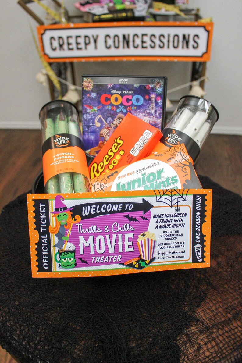 May include: A Halloween movie night themed gift basket with a DVD of the movie "Coco", candy, and other treats. The basket is decorated with a ticket that says "Welcome to Thrills & Chills Movie Theater".