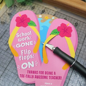 May include: Pink and yellow flip-flop shaped card with the text "School work: GONE Flip flops: ON" and "Thanks for being a toe-tally awesome teacher!"  The card also includes a hibiscus flower and the text "Have a great summer! Love, Easton".