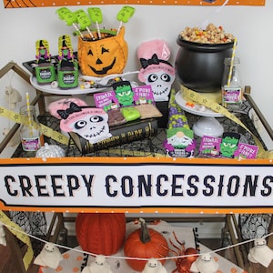May include: A Halloween-themed party cart with a sign that reads "Creepy Concessions". The cart is decorated with pumpkins, ghosts, and other Halloween decorations. There are also various treats and snacks on the cart, including popcorn, candy, and drinks.