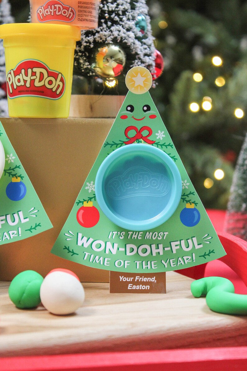 May include: A green and white Christmas tree-shaped card with a blue Play-Doh container in the center. The card says "It's the most Won-Doh-Ful time of the year!" and "Your Friend, Easton".