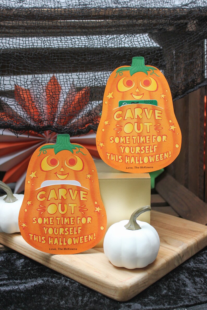 May include: Two orange pumpkin-shaped cards with a cut-out slot for a gift card. The cards have a smiling pumpkin face and the text "CARVE OUT SOME TIME FOR YOURSELF THIS HALLOWEEN! Love, The McKowns".