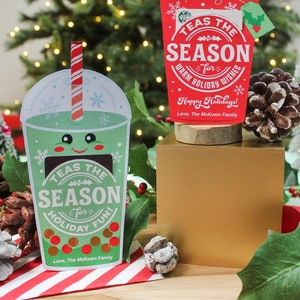 Pode incluir: Dois cart&otilde;es de presente de Natal festivos em forma de x&iacute;caras de caf&eacute;. A x&iacute;cara verde diz "TEAS THE SEASON for HOLIDAY FUN!" e a x&iacute;cara vermelha diz "TEAS THE SEASON for WARM HOLIDAY WISHES! Happy Holidays! Love, The McKown Family."