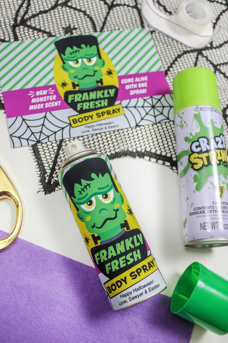 May include: Two green and white spray bottles with a monster design. The bottles are labelled "Frankly Fresh Body Spray" and "Crazy Strong". The bottles are on a black and white spiderweb pattern background.