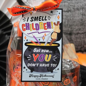 May include: A Halloween gift bag with a tag that says "I smell children! But now... you don't have to! Happy Halloween! Love, Easton". The bag contains a bottle of orange liquid with a skeleton hand design and a candle with a pumpkin and skeleton design.