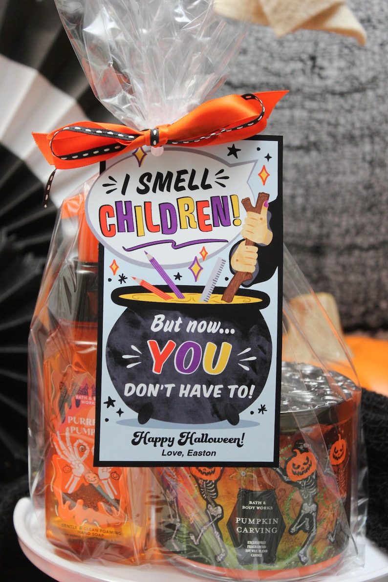 May include: A Halloween gift bag with a tag that says "I smell children! But now... you don't have to! Happy Halloween! Love, Easton". The bag contains a bottle of orange liquid with a skeleton hand design and a candle with a pumpkin and skeleton design.