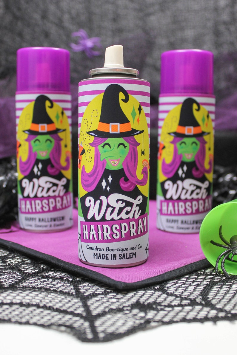 May include: Three purple and white aerosol cans with a witch illustration and the text "Witch Hairspray" on the label. The label also says "Cauldron Boo-tique and Co. Made in Salem".